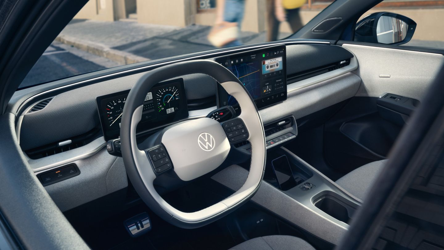 "Rálátás a VW ID. Polo műszerfalára a nyitott vezetőoldali ajtón keresztül, miközben az autó az út szélén parkol. "