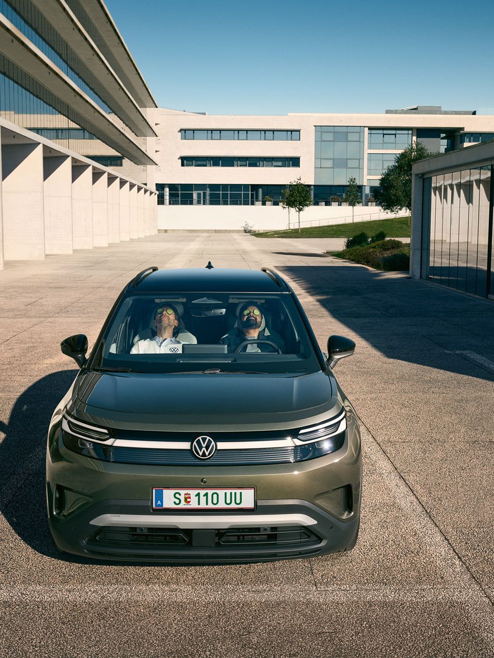 Két férfi hátradőlve, csukott szemmel ül egy VW ID.Cross első ülésein. 
