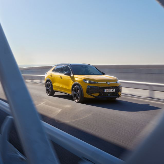 egy sárga t-roc napfényes hídon halad