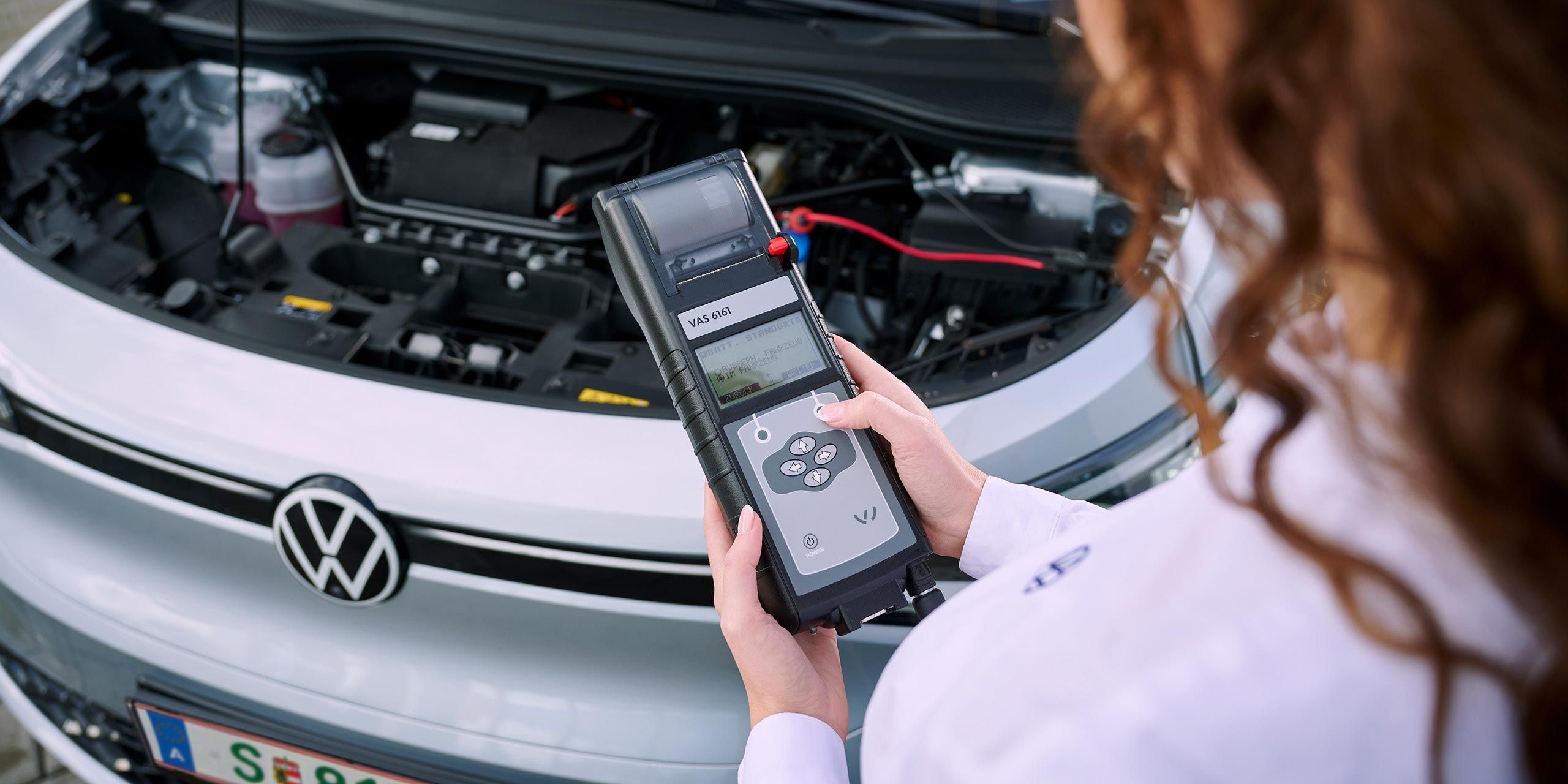 Eine VW Technikerin beim Elektroautoservice für einen Volkswagen ID