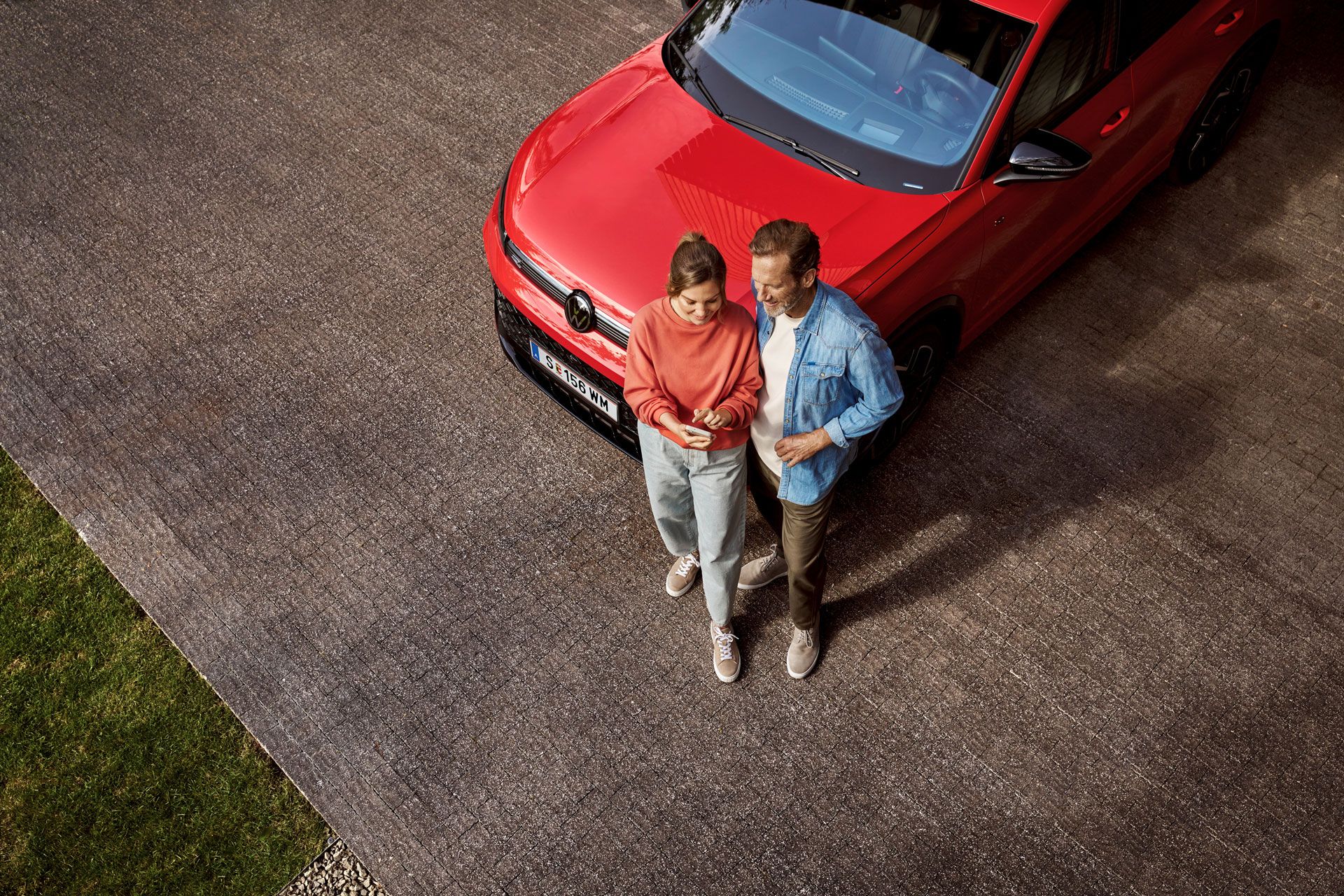 Nő és férfi egy piros VW modell előtt