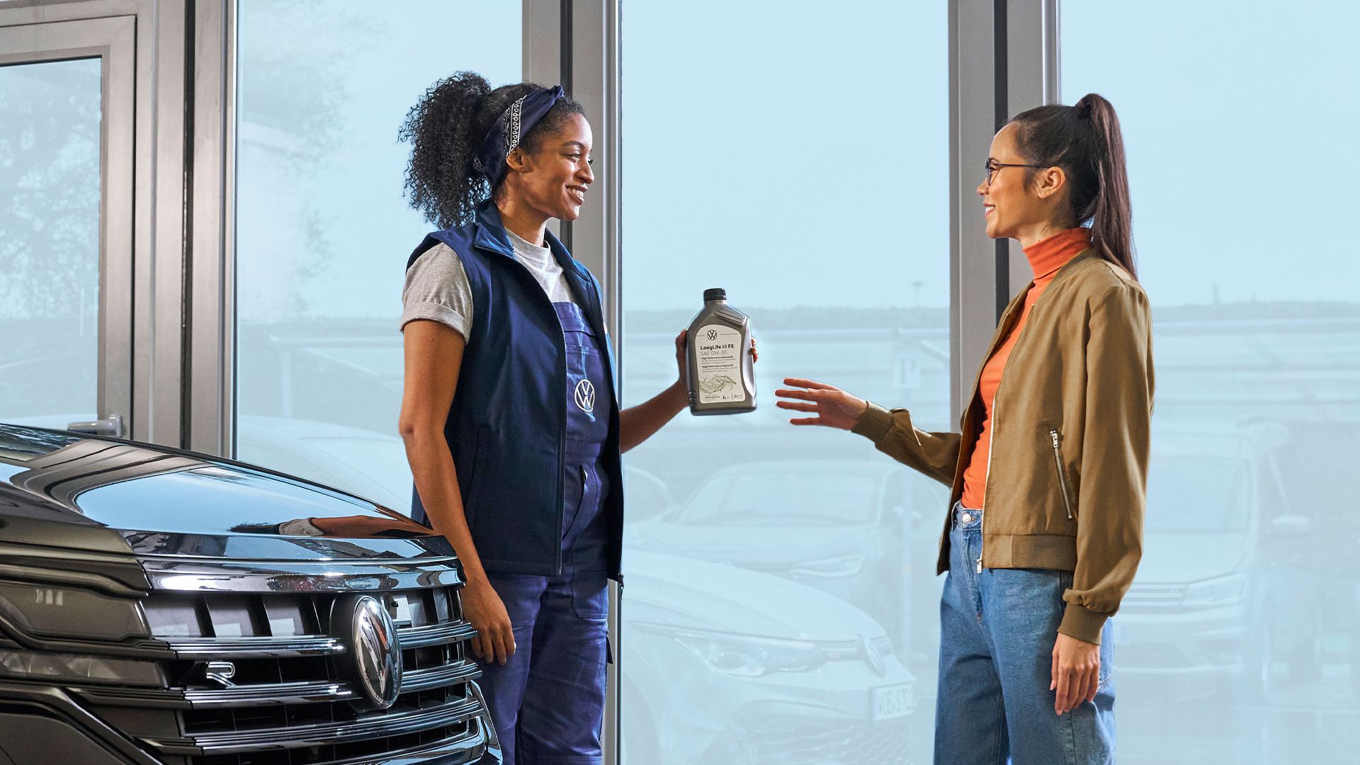 egy VW szervizes átad egy olajat egy ügyfélnek
