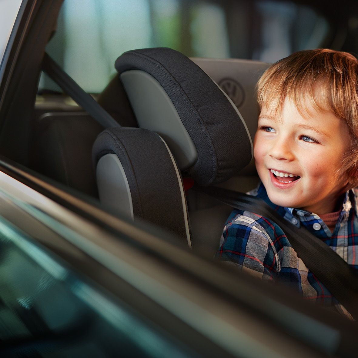 Kisfiú gyerekülésben néz ki az ablakon