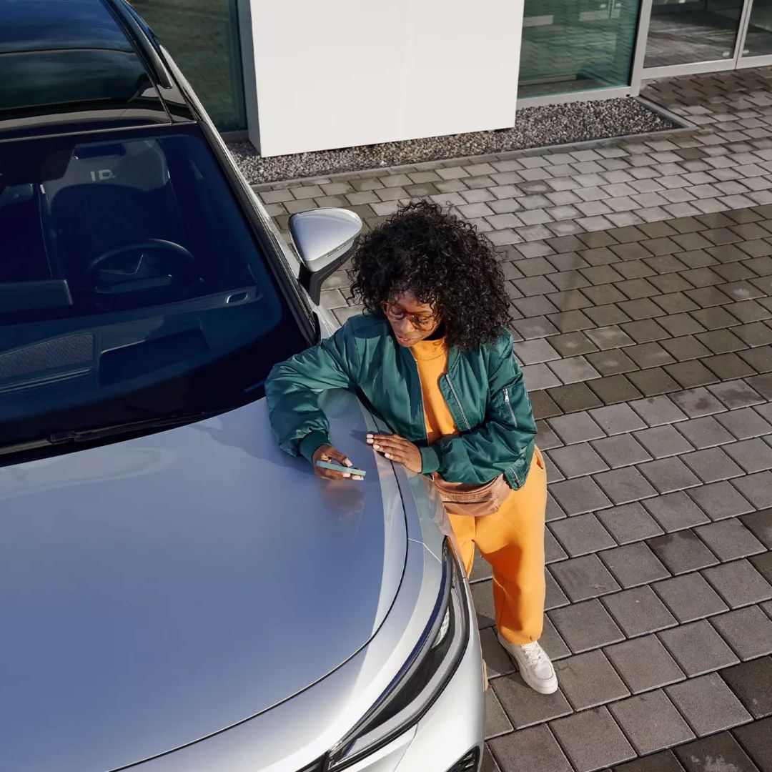 Egy nő egy VW modell motorháztetejére dől