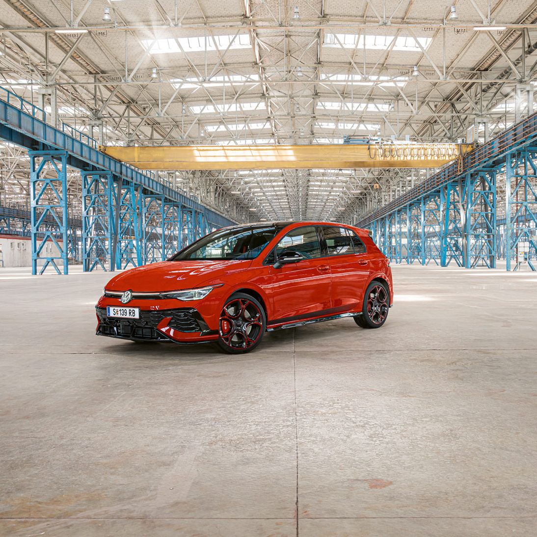 Piros Golf GTI áll egy nagy gyár üres épületében.
