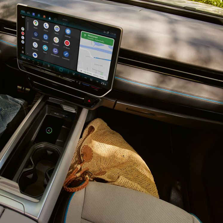 Blick auf die Mittelkonsole des VW ID.7 in dem verbundenes Smartphone liegt