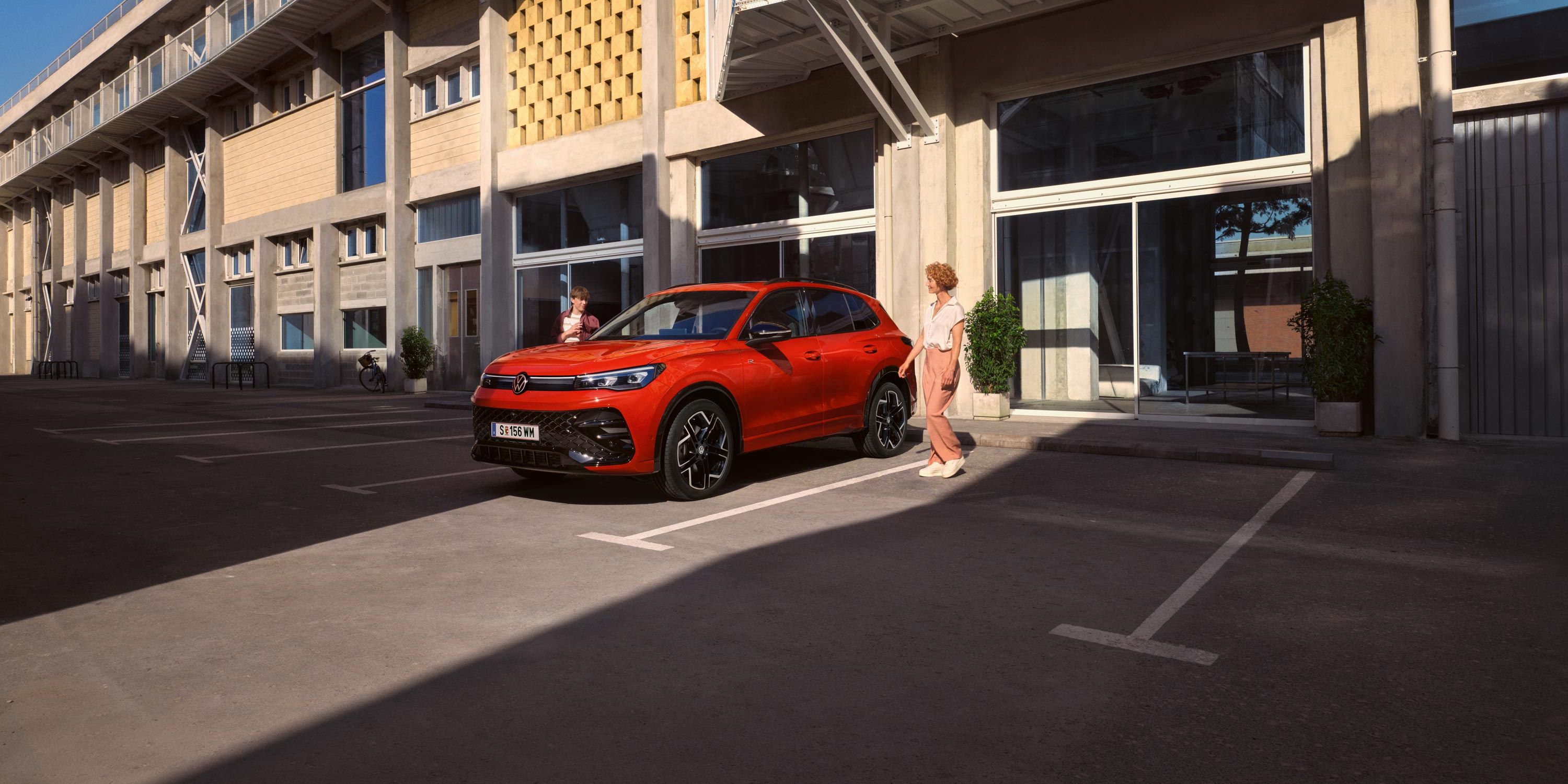 Tiguan egy épület előtt parkol
