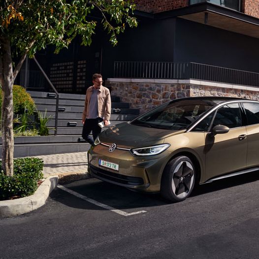 Ein VW ID.3 in olivgrün ist in einer Stadt geparkt, seitliche Ansicht