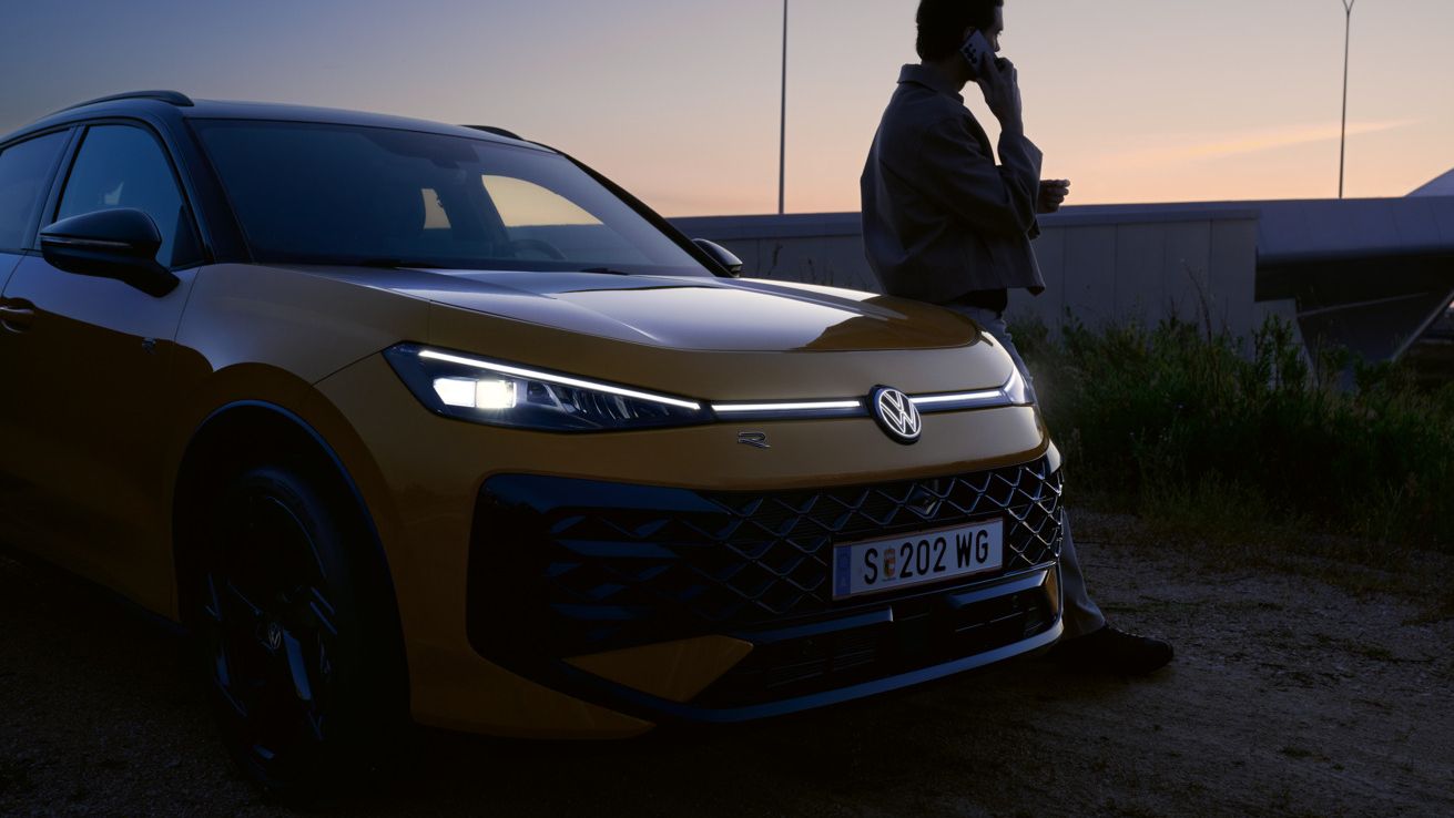 T-Roc fényszórói, az autó mellett egy férfi telefonál