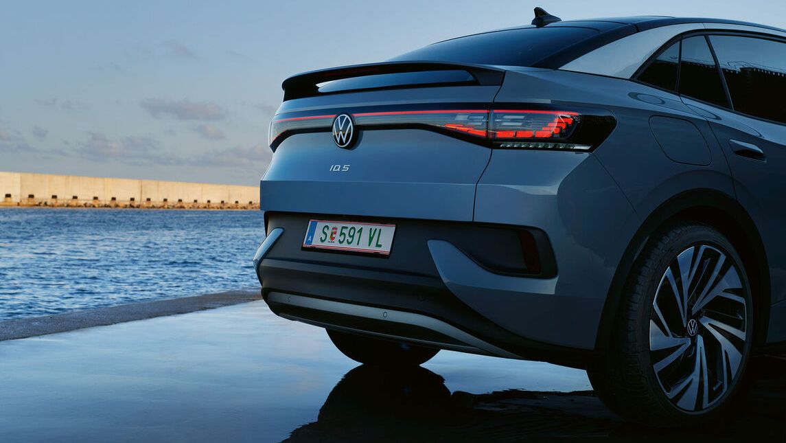 Hölgy áll a VW T-Roc Cabriolet előtt 