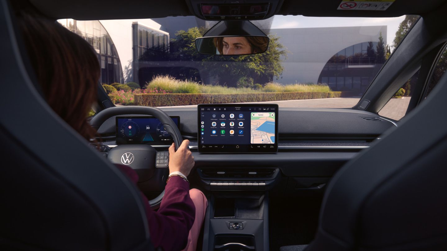 Egy nő a vezetőoldal felől megérinti a központi kijelzőt egy VW ID.3 Neo modellben. 