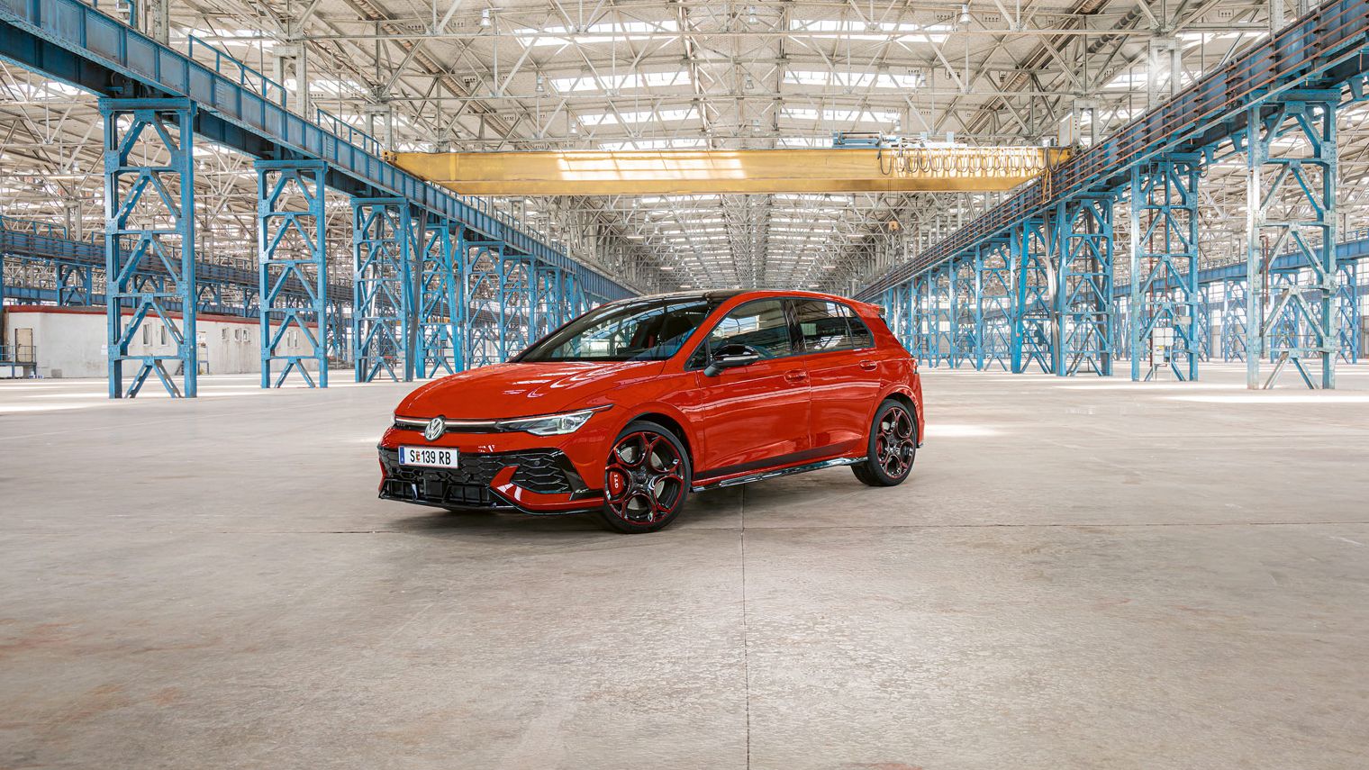 Piros Golf GTI áll egy nagy gyár üres épületében.