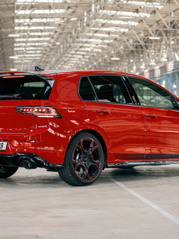 Piros VW Golf GTI áll egy nagy gyárépületben