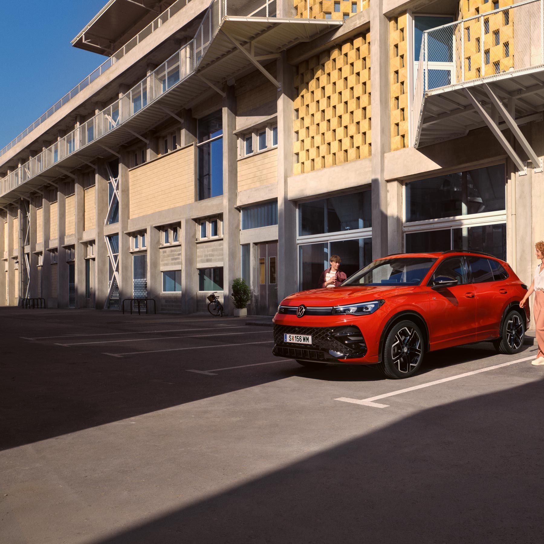 Tiguan egy épület előtt parkol
