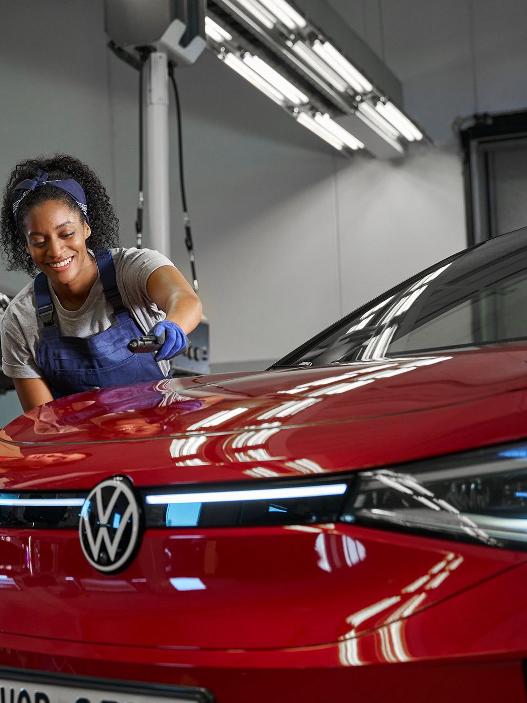 Eine Volkswagen Technikerin erklärt einer Kundin die Lackreparatur