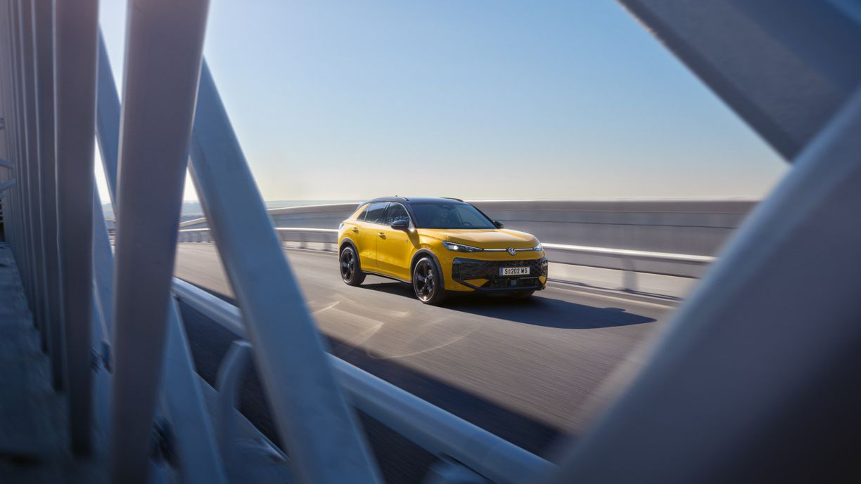 egy sárga t-roc napfényes hídon halad
