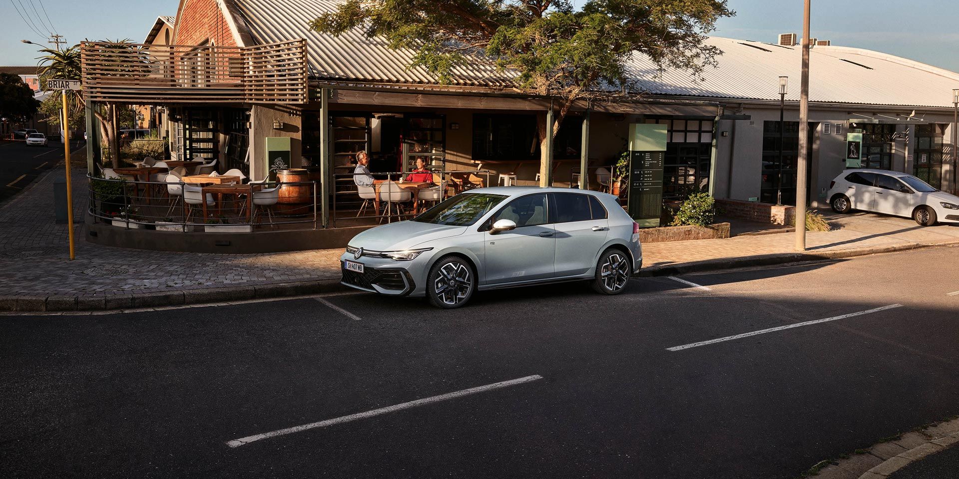 Bel Golf R-Line bočno parkira pred restavracijo.