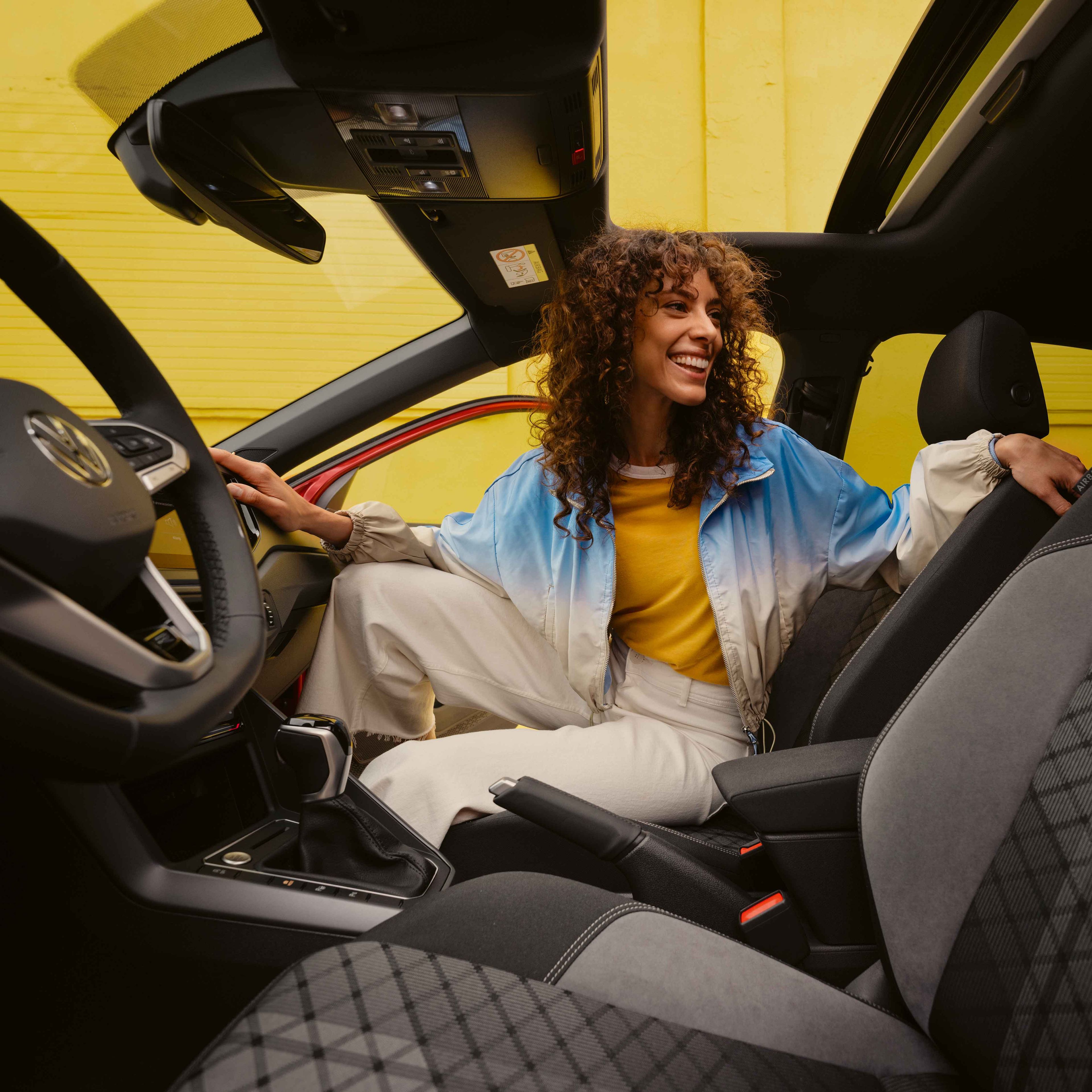 VW Taigo R-Line Interieur: Frau sitzt auf Beifahrersitz und schaut nach hinten