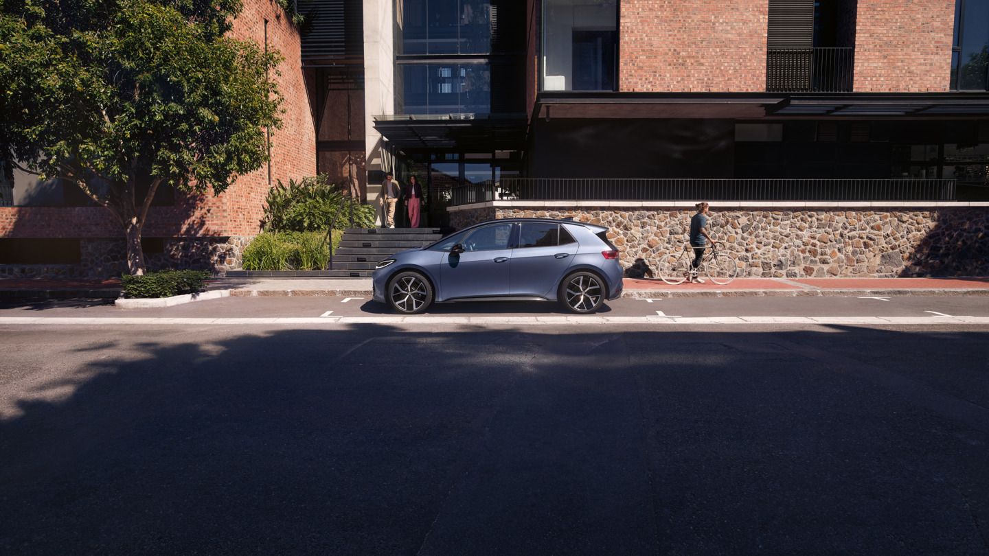 Kék VW ID.3 Neo parkol egy lakás előtt.