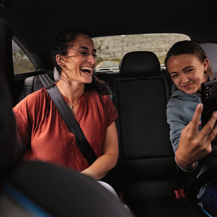 Zwei Frauen haben Spass auf dem Rücksitz eines Volkswagen