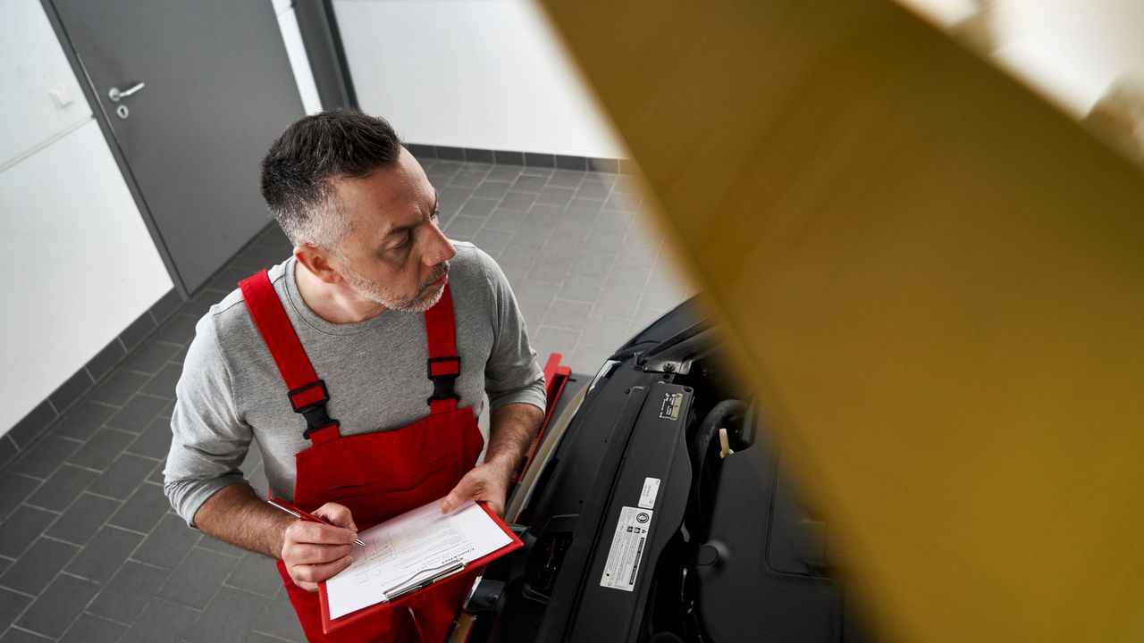 Ein Volkswagen Techniker begutachtet einen Volkswagen e-up!