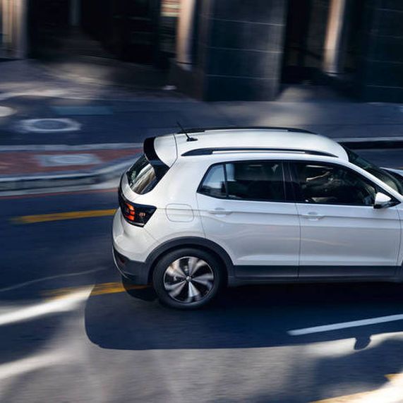 Fehér Volkswagen T-Cross kanyarodik