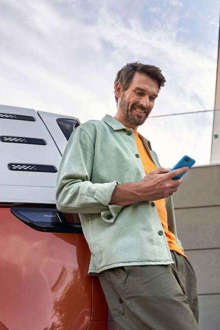 Im Mann mit Smartphone lehnt an einem ID. Buzz