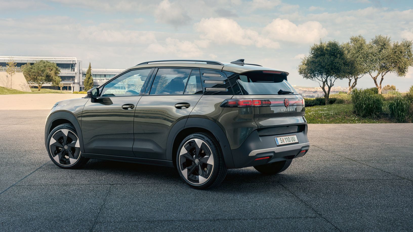 Egy zöld VW ID. Cross hátulnézetből, amint egy zöld fákkal övezett téren parkol.