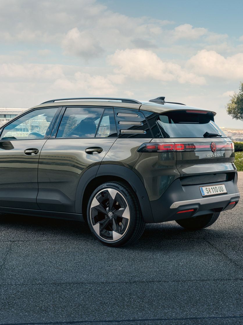 Egy zöld VW ID. Cross hátulnézetből, amint egy zöld fákkal övezett téren parkol.