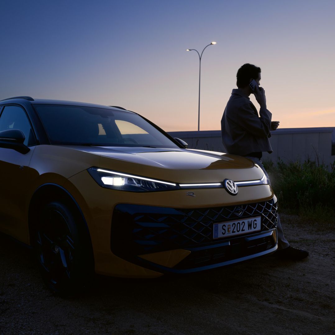 T-Roc fényszórói, az autó mellett egy férfi telefonál