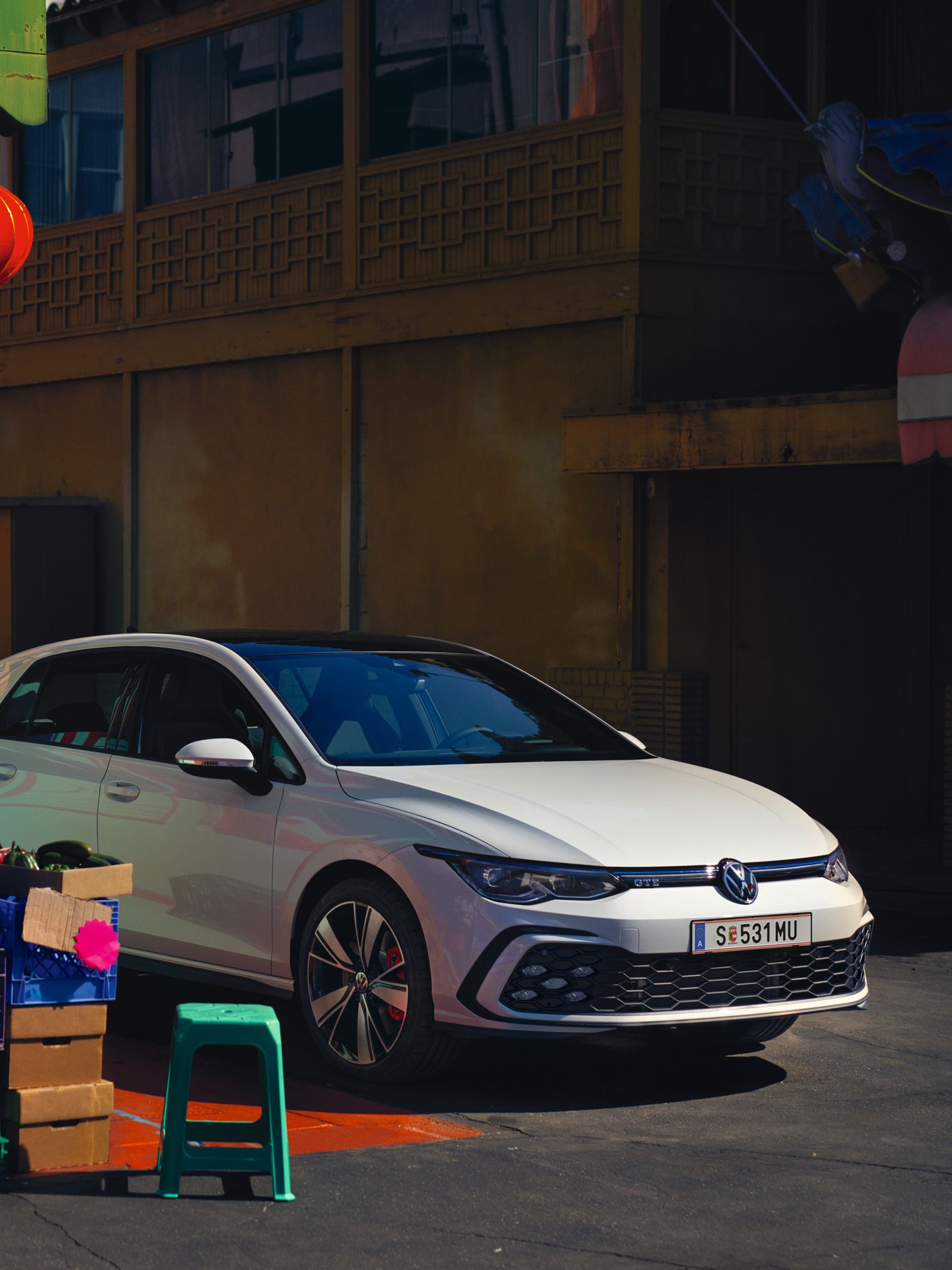 Frau steht seitlich von VW Golf GTE 